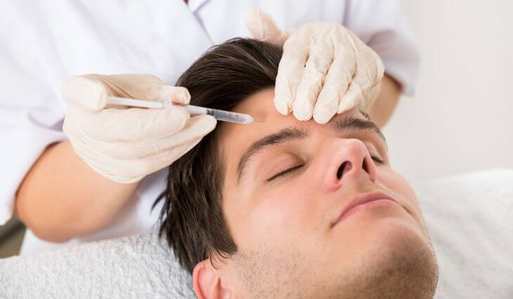 A man at a medspa getting botox forehead lines treatment 