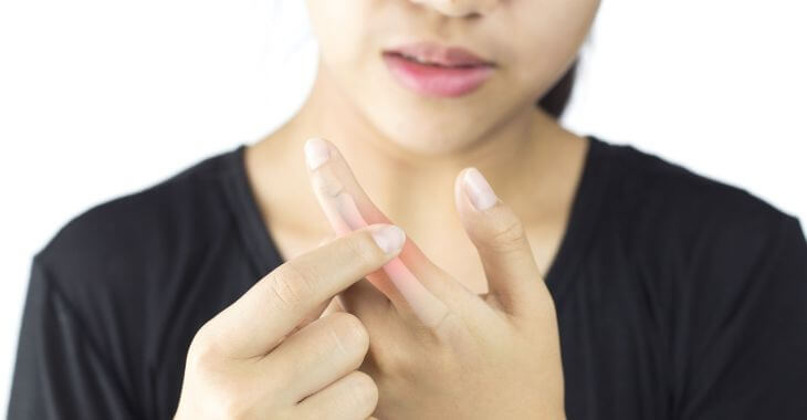 A concerned woman self-examining her painful injured finger