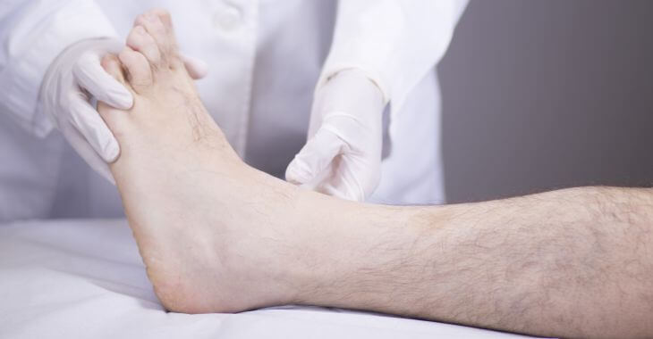 A doctor examining patient's ankle