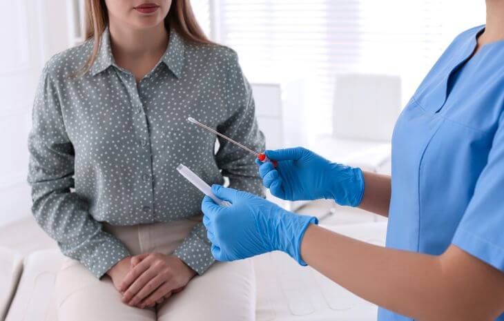 A nurse explaining the STD testing procedure to a female patient