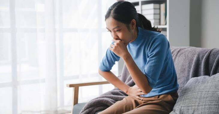 An Asian woman feeling pelvic pain while coughing